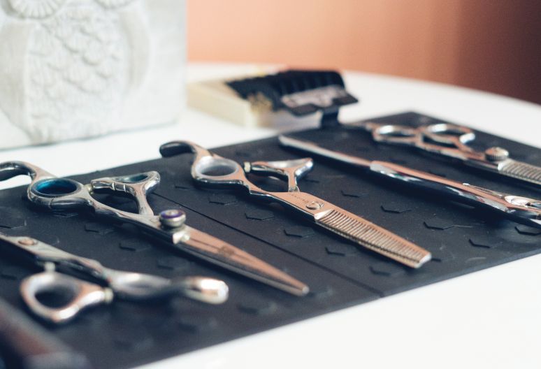 Barber tools and scissors arranged on desk